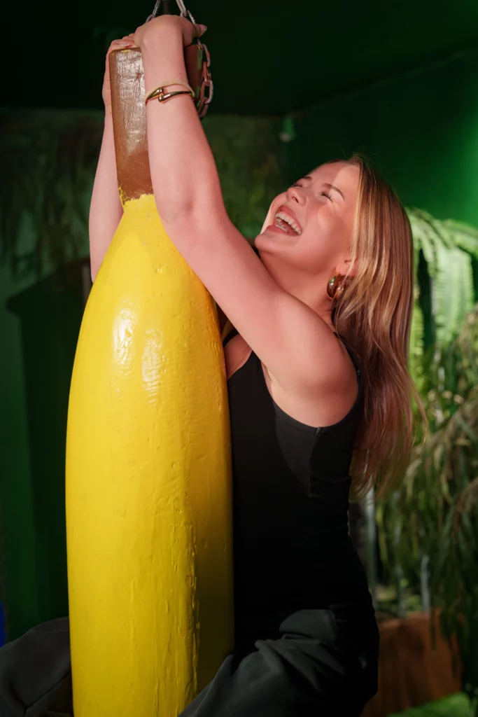 a person hanging on a giant banana